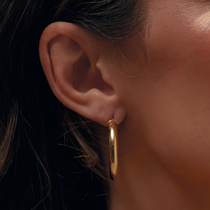 14K Yellow Gold Round Tube Hoop Earrings on ear